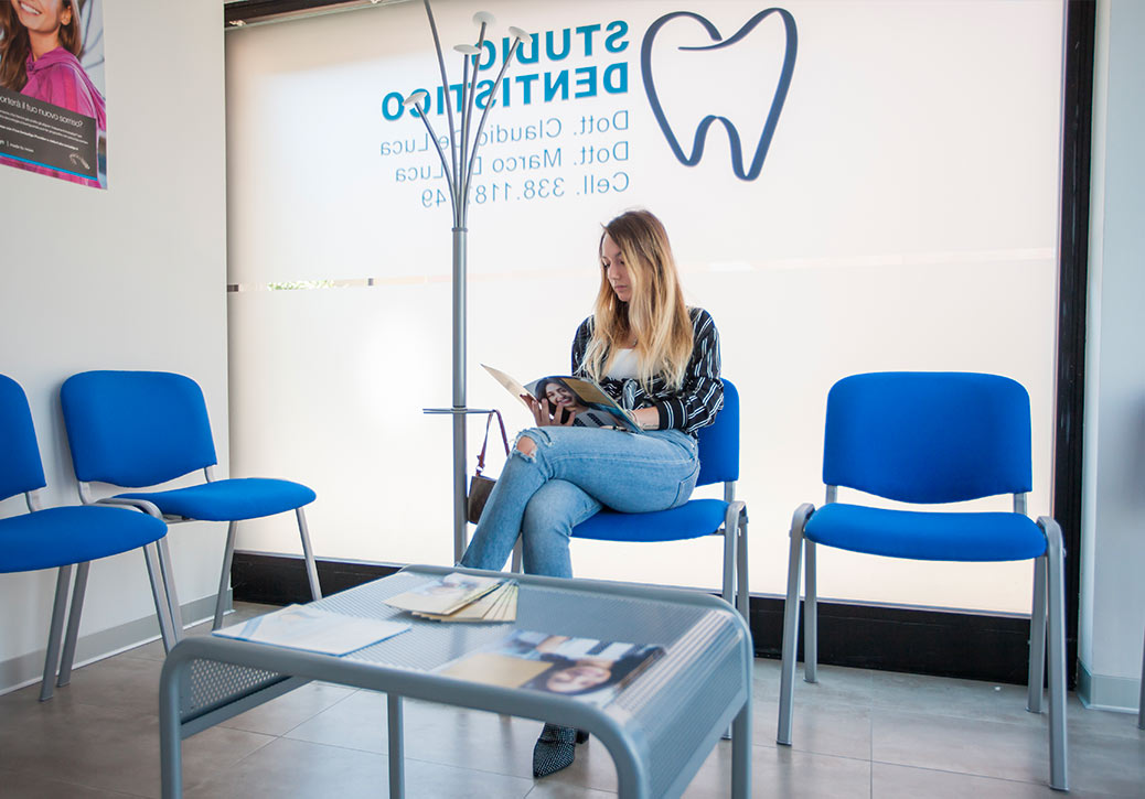 Dentista a Concorezzo: Ragazza seduta legge giornale in sala di attesa