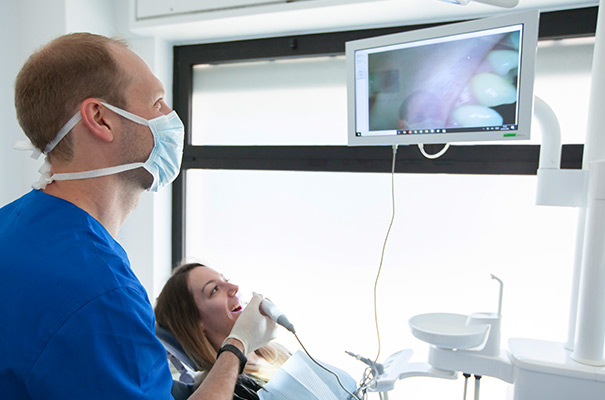 Dentista a Concorezzo: Dottore che visita la paziente in studio
